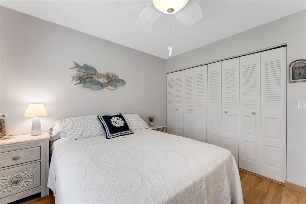 3140 Highlands Boulevard, Unit F Palm Harbor, FL 34684 - Photo 24 of 78 a bedroom with a bed and a night stand