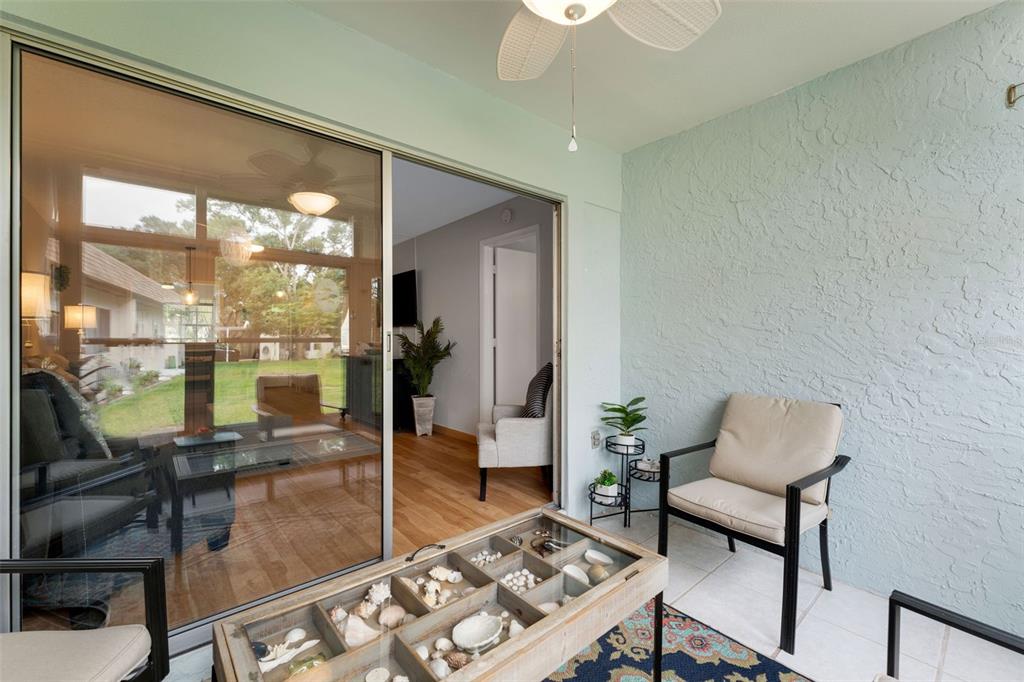 3140 Highlands Boulevard, Unit F Palm Harbor, FL 34684 - Photo 30 of 78 a living room with furniture and a floor to ceiling window