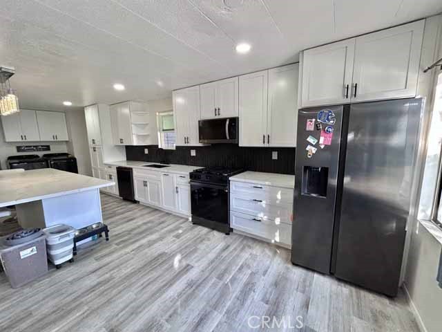 2751 Reche Canyon Road Moreno Valley, CA 92555 - Photo 9 of 20 a kitchen with stainless steel appliances a refrigerator stove microwave and cabinets