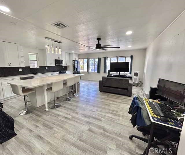 2751 Reche Canyon Road Moreno Valley, CA 92555 - Photo 10 of 20 a view of a kitchen with kitchen island a dining table chairs and a refrigerator