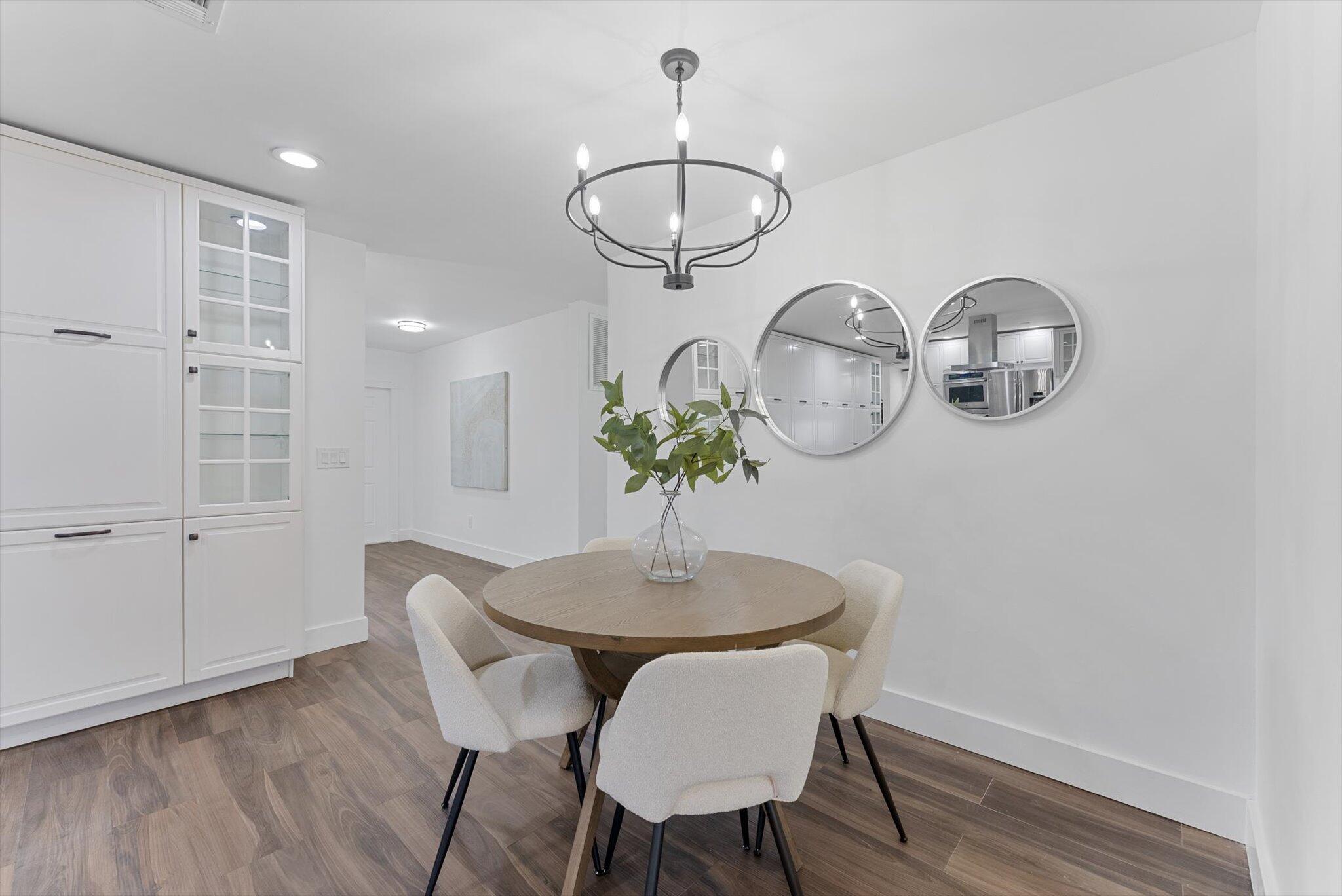 5412 Arthur Street Hollywood, FL 33021 - Photo 19 of 67 a dining room with wooden floor a chandelier a wooden table and chairs