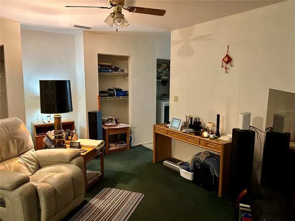 a living room with furniture ceiling fan and a window
