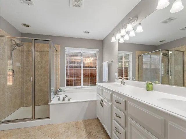 a bathroom with a tub sink and mirror