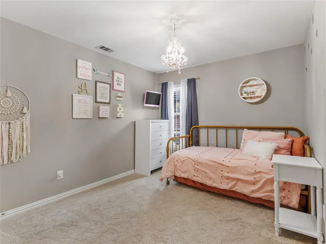 a bedroom with a bed and a chandelier