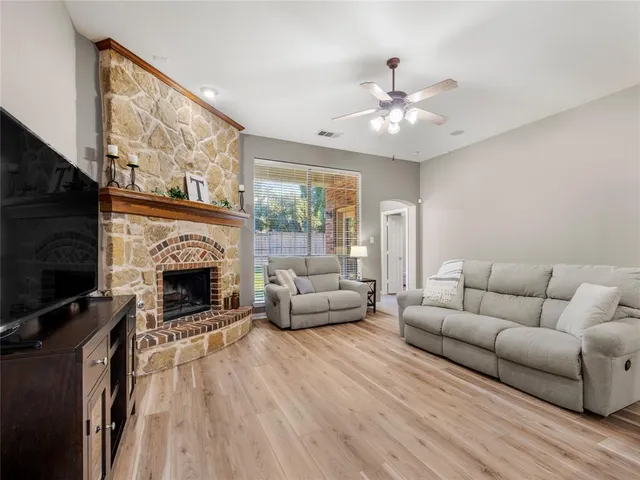 a living room with furniture a flat screen tv and a fireplace