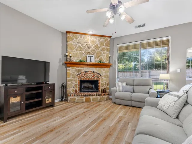 a living room with furniture a flat screen tv and a fireplace
