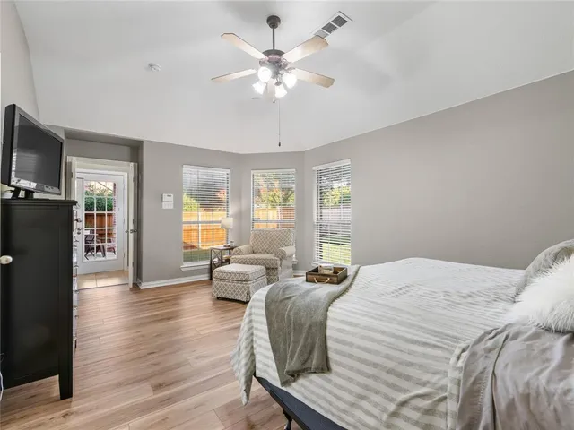 a bedroom with a large bed a chandelier and windows