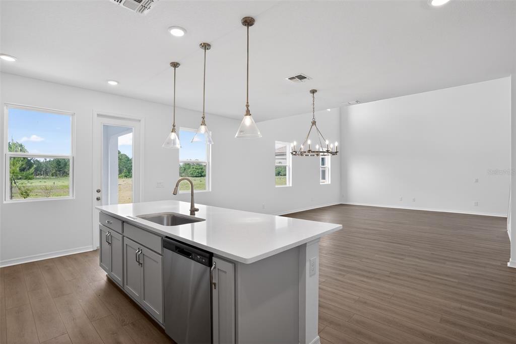 5788 Haystack Drive St. Cloud, FL 34771 - Photo 18 of 31 a kitchen with stainless steel appliances granite countertop a sink a window and wooden floor