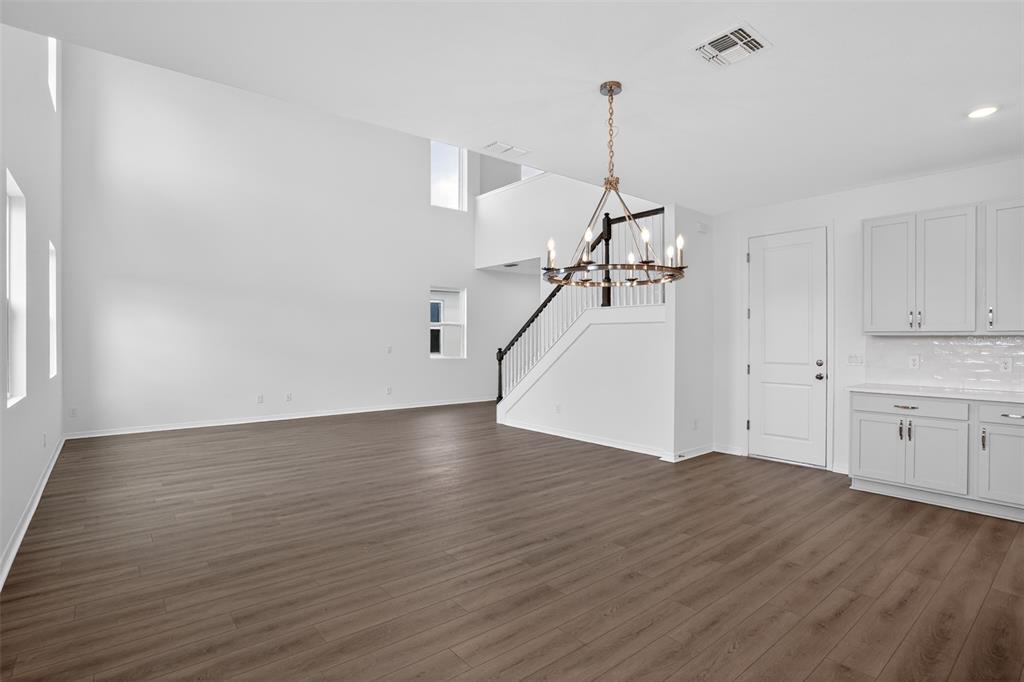 5788 Haystack Drive St. Cloud, FL 34771 - Photo 8 of 31 a view of a room with wooden floor ceiling fan and windows