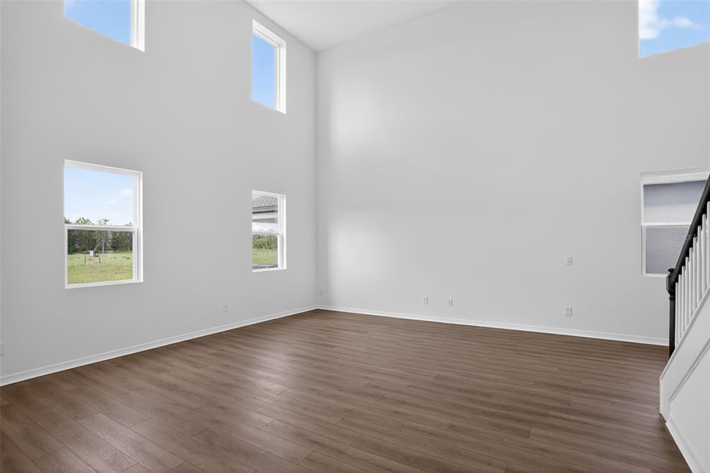 5788 Haystack Drive St. Cloud, FL 34771 - Photo 9 of 31 a view of an empty room with wooden floor and a window