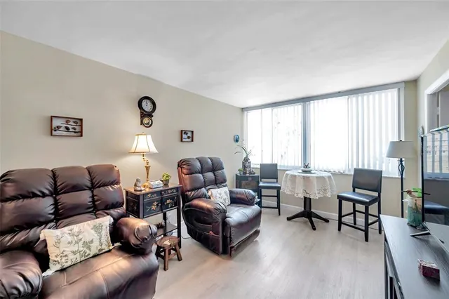 a living room with furniture and a dining table with wooden floor