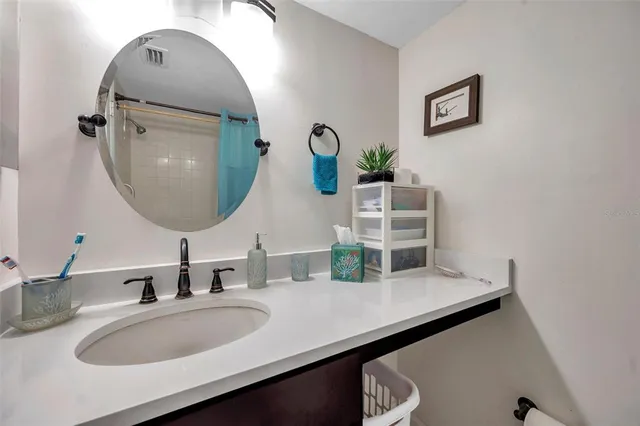 a bathroom with a granite countertop sink vanity mirror and toilet