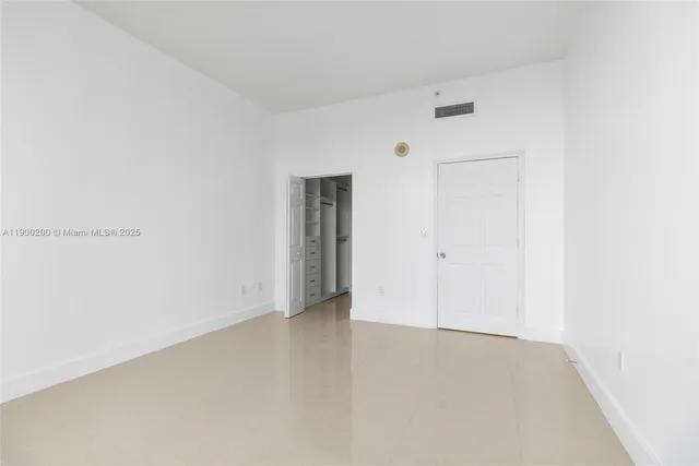 a view of a room with a ceiling fan and entryway