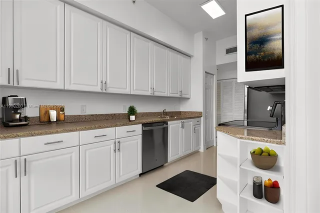 a kitchen with stainless steel appliances granite countertop a sink stove and cabinets