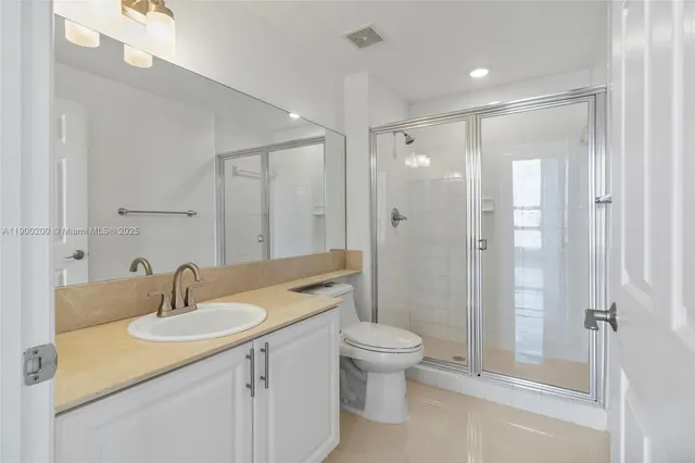 a bathroom with a bathtub shower sink vanity mirror and toilet
