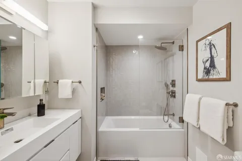 a bathroom with a tub sink toilet and a mirror