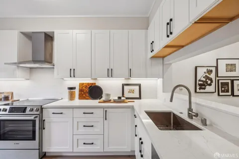 a kitchen with white cabinets and sink