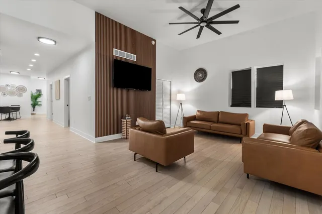 a living room with furniture and a wooden floor