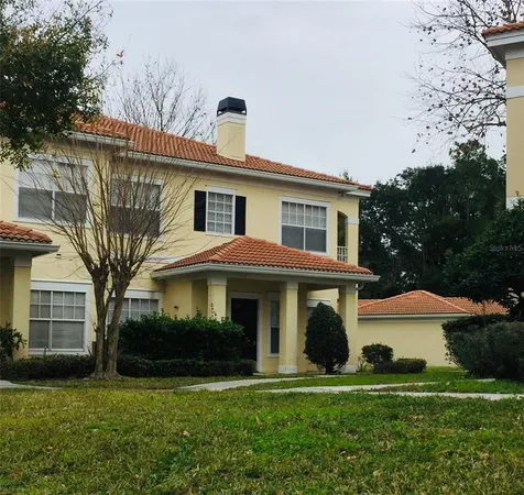 a front view of a house with a yard and trees