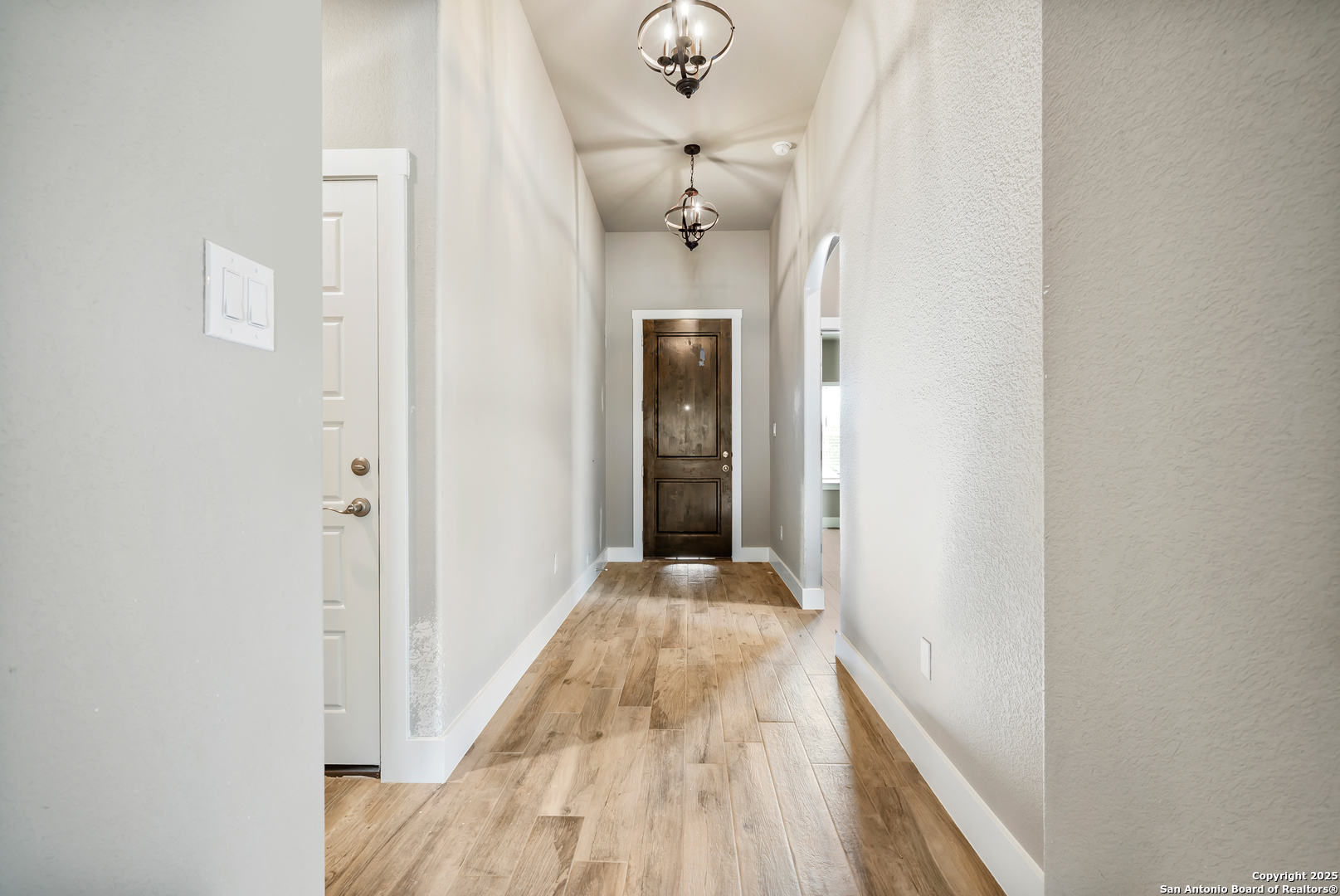 141 Prairie Tea Spring Branch, TX 78070 - Photo 6 of 26 a view of a hallway with wooden floor and a chandelier
