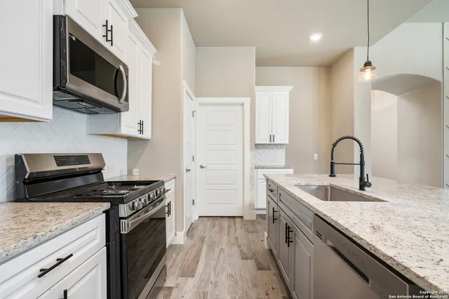 a kitchen with stainless steel appliances granite countertop a sink and a stove