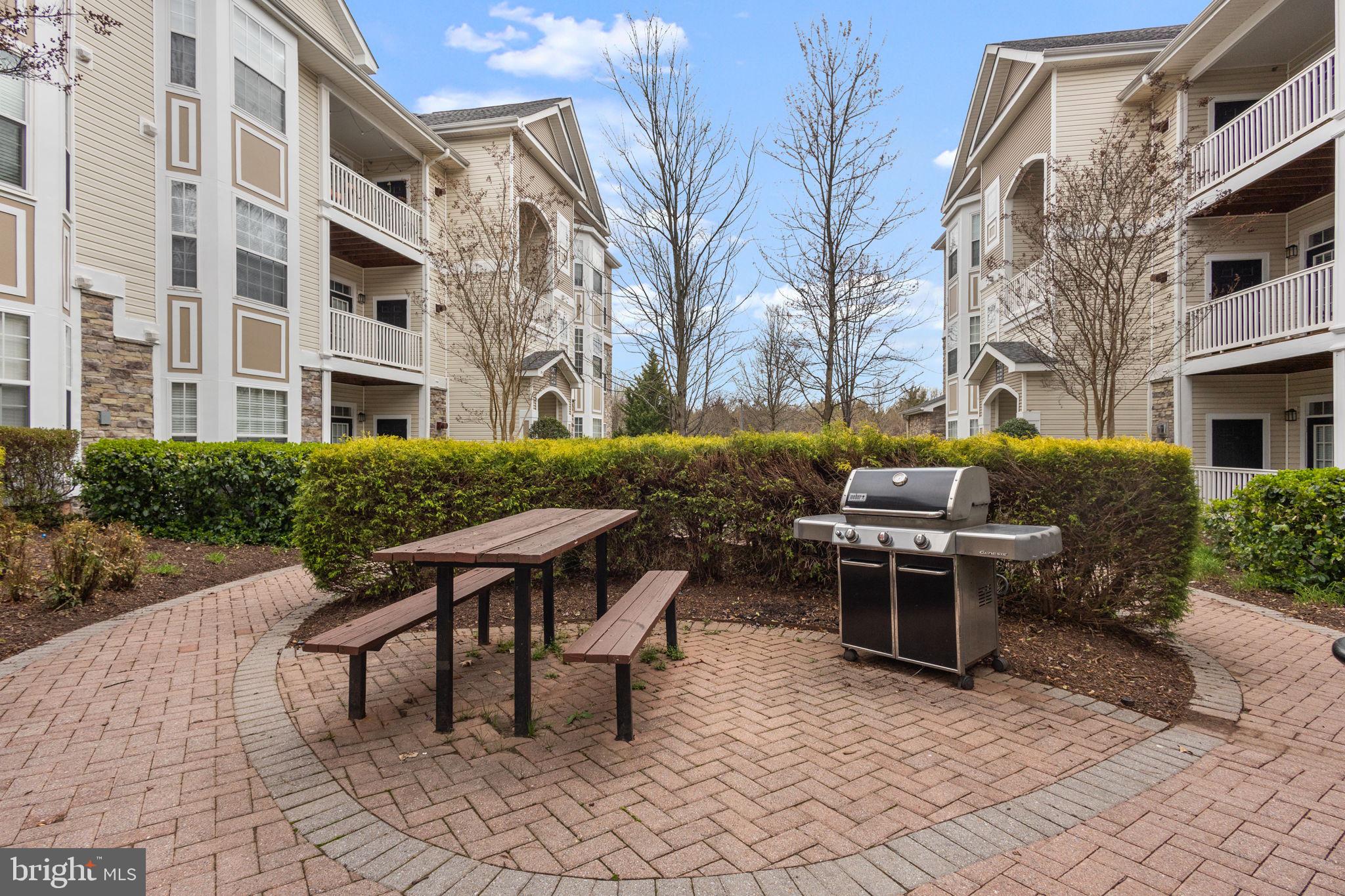 508 Sunset View Terrace Southeast, Unit 302 Leesburg, VA 20175 - Photo 26 of 30 a backyard of a house with barbeque oven table and chairs