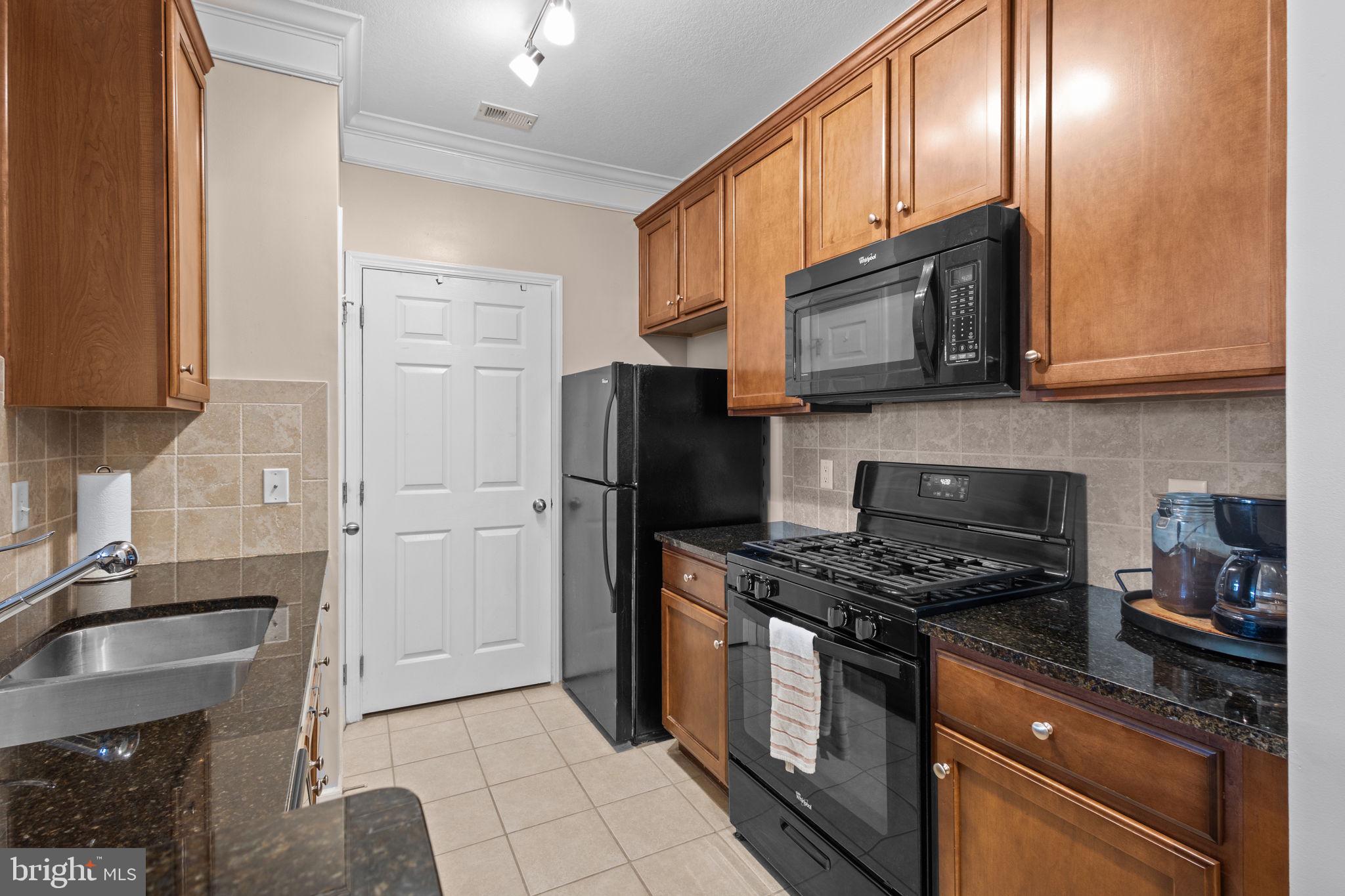 508 Sunset View Terrace Southeast, Unit 302 Leesburg, VA 20175 - Photo 7 of 30 a kitchen with stainless steel appliances granite countertop a stove microwave refrigerator and sink
