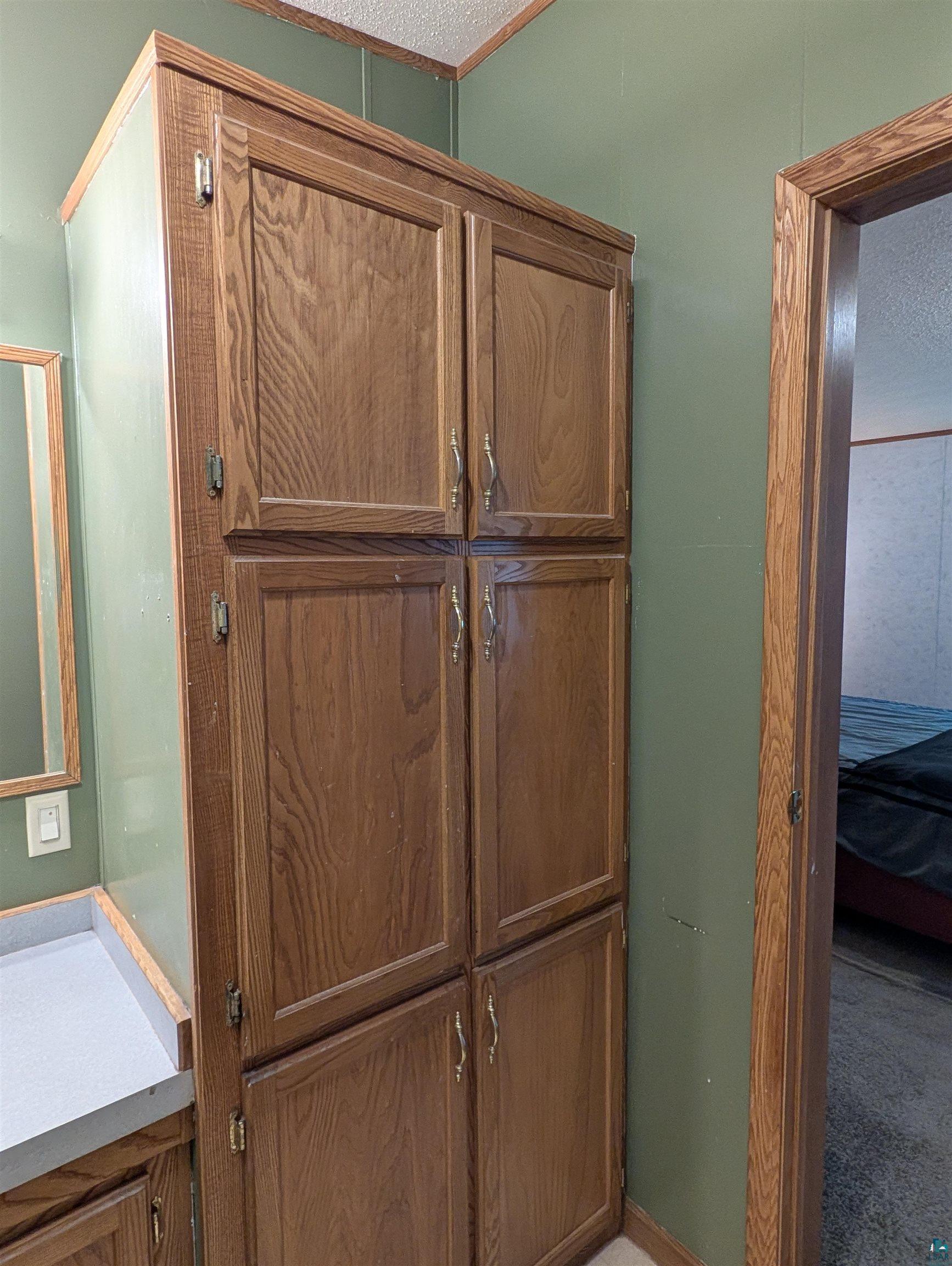 3945 Maple Street Kettle River, MN 55757 - Photo 32 of 41 Floor-to-ceiling wood-finish storage cabinetry featuring brass-tone hardware