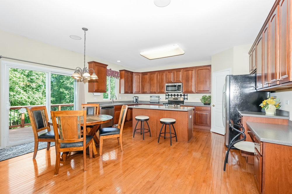 1616 Boulder Ridge Drive Bolingbrook, IL 60490 - Photo 8 of 35 a view of a dining room and livingroom with furniture wooden floor a chandelier