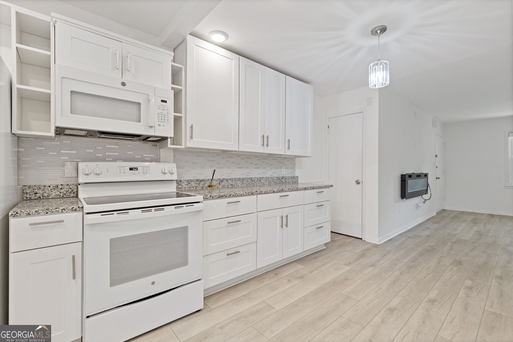 3510 Roswell Road Northwest, Unit C2 Atlanta, GA 30305 - Photo 10 of 24 a kitchen with granite countertop white cabinets and white appliances