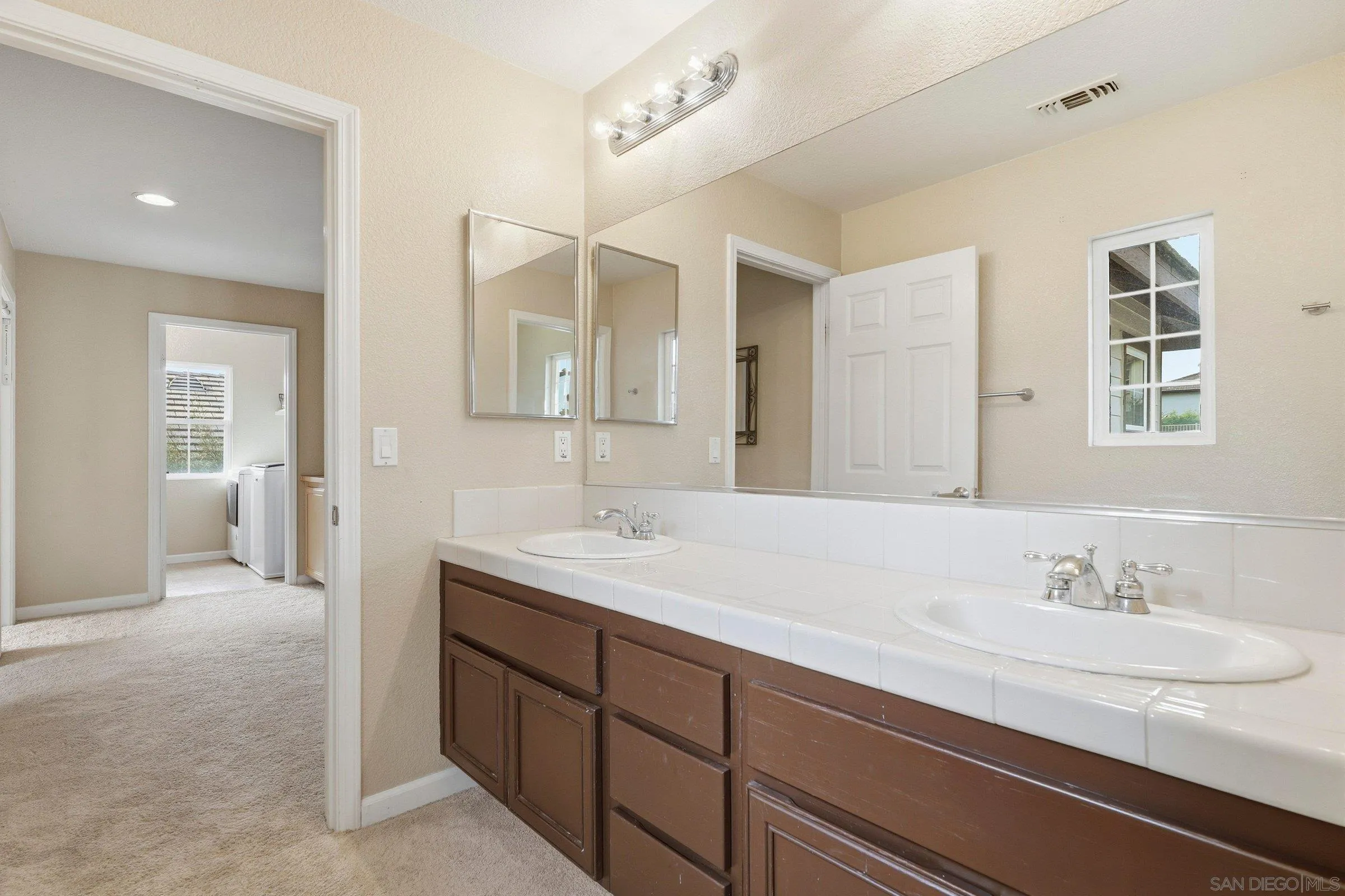 1514 West Borden Road San Marcos, CA 92069 - Photo 30 of 40 a spacious bathroom with a double vanity sink and a mirror