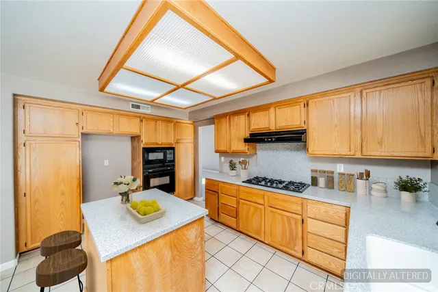 a kitchen with stainless steel appliances kitchen island granite countertop a refrigerator and cabinets