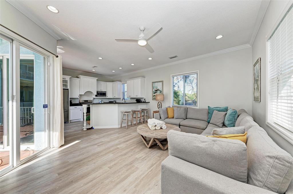 201 57th Street Holmes Beach, FL 34217 - Photo 11 of 48 a living room with couches and kitchen view with wooden floor