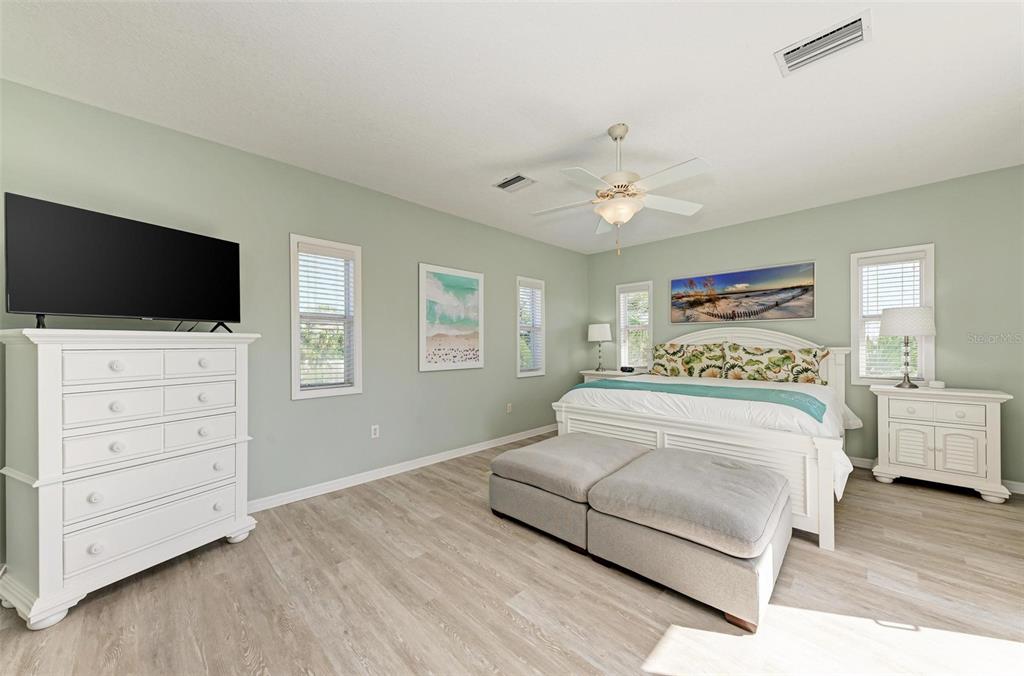 201 57th Street Holmes Beach, FL 34217 - Photo 22 of 48 a bedroom with a large bed and a flat screen tv