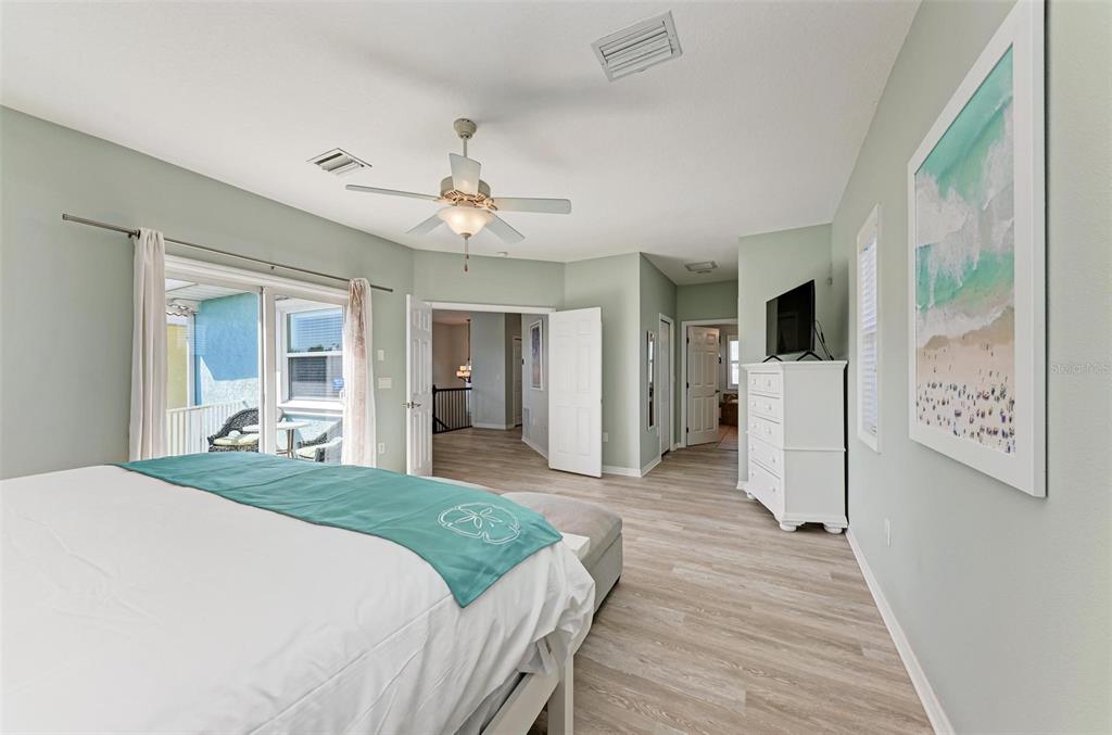 201 57th Street Holmes Beach, FL 34217 - Photo 24 of 48 a bedroom with a large bed and a chandelier
