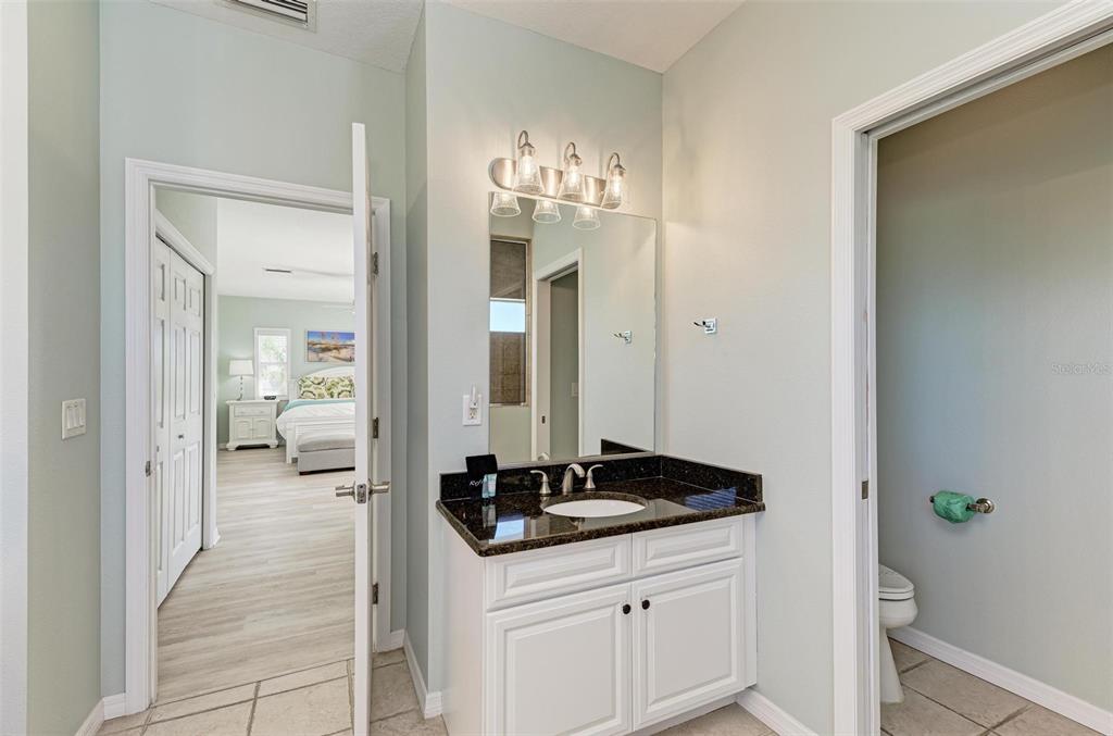 201 57th Street Holmes Beach, FL 34217 - Photo 29 of 48 a en suite bathroom with a sink and a mirror