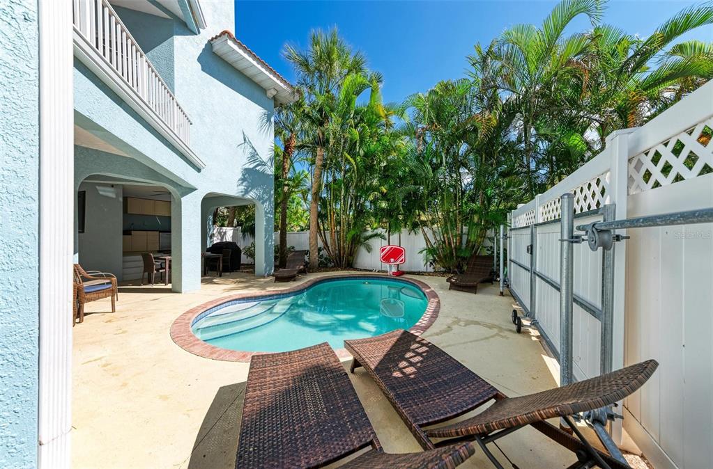 201 57th Street Holmes Beach, FL 34217 - Photo 37 of 48 a backyard of a house with table and chairs