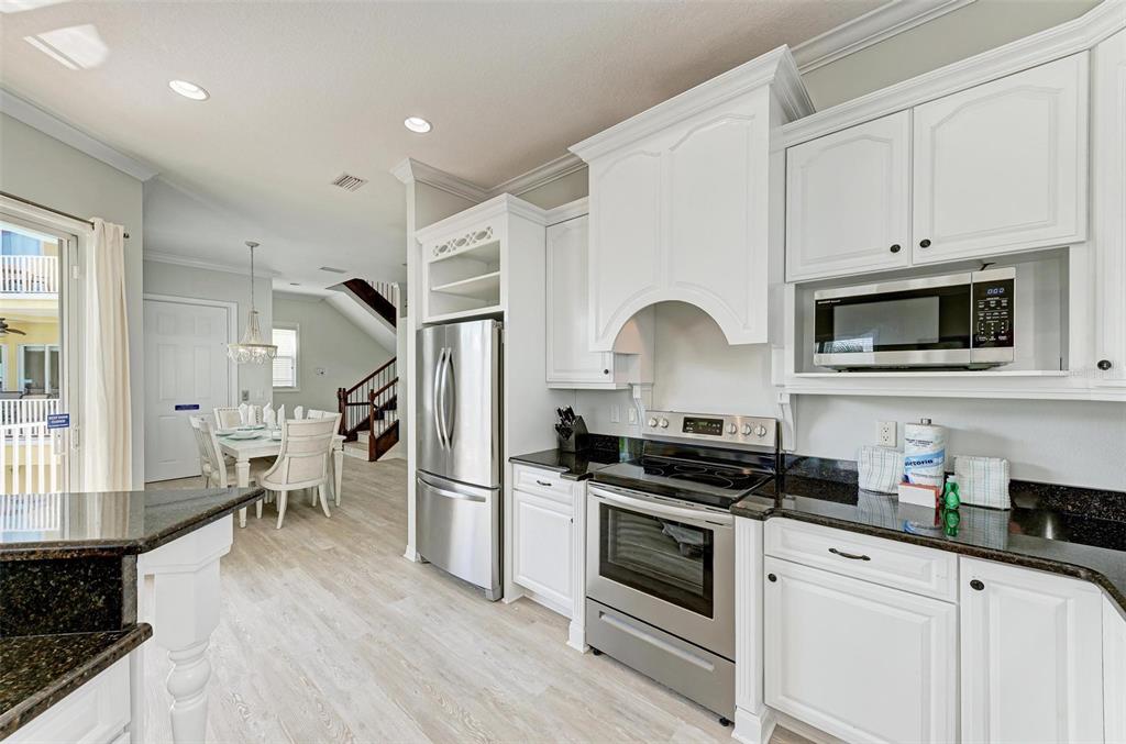 201 57th Street Holmes Beach, FL 34217 - Photo 4 of 48 a kitchen with white cabinets and appliances