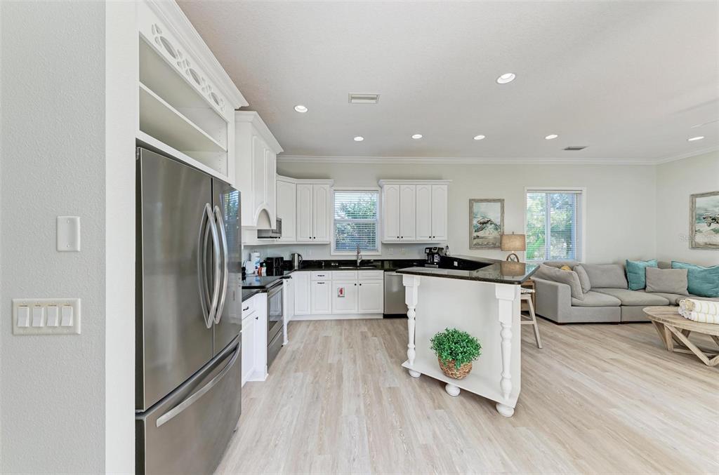 201 57th Street Holmes Beach, FL 34217 - Photo 5 of 48 a kitchen with a refrigerator a sink and white cabinets