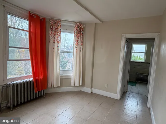 a view of a room with a large window and an empty room