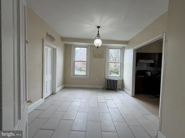 an empty room with windows and a chandelier
