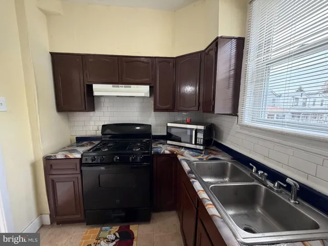 a kitchen with a sink stove top oven and cabinets