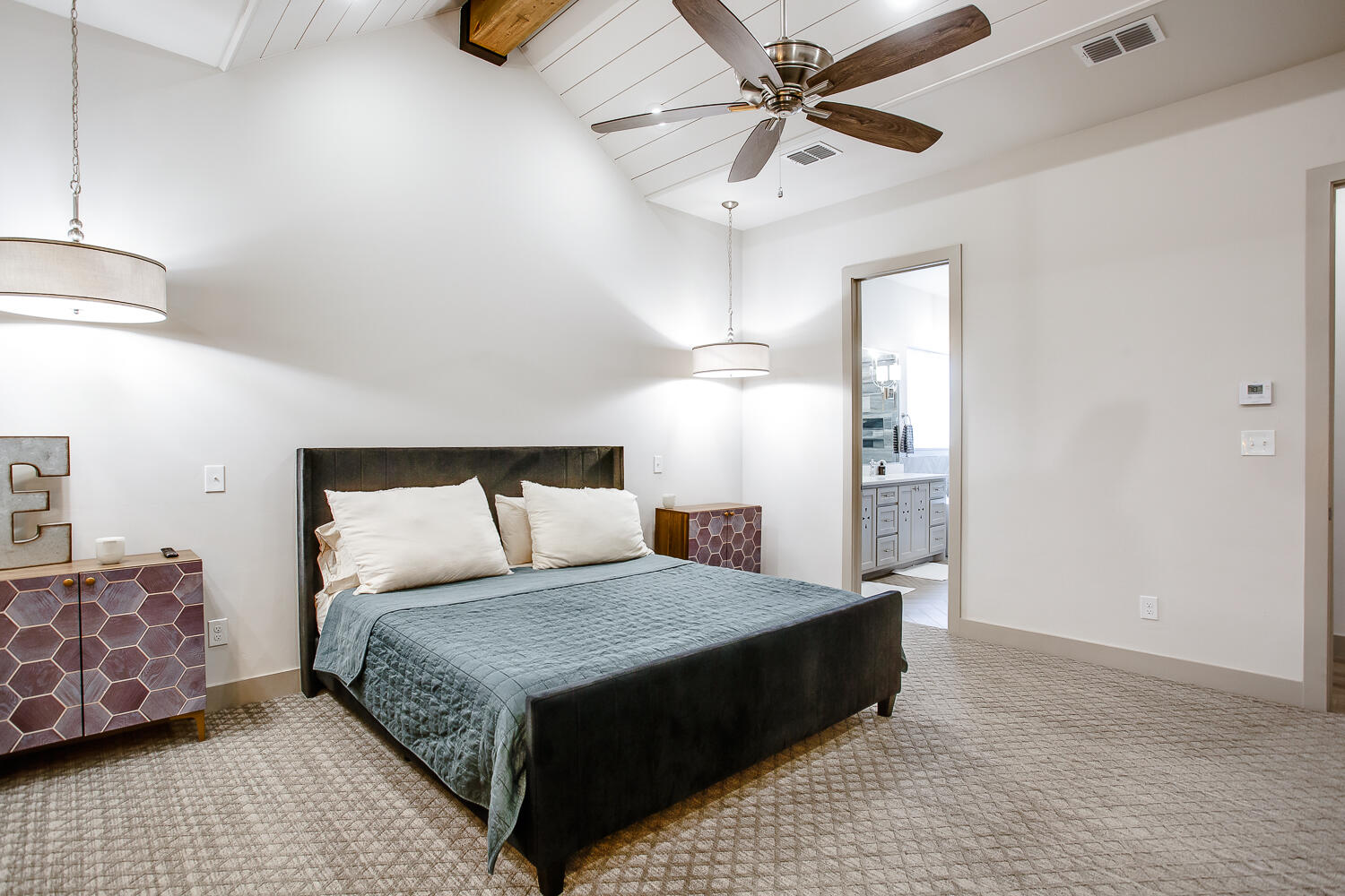 7601 53rd Street Lubbock, TX 79407 - Photo 16 of 33 a bedroom with a large bed and a chandelier