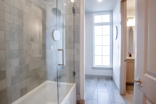 a bathroom with a tub shower and sink
