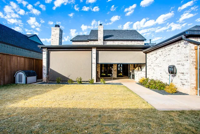 a view of a house with backyard and a tree