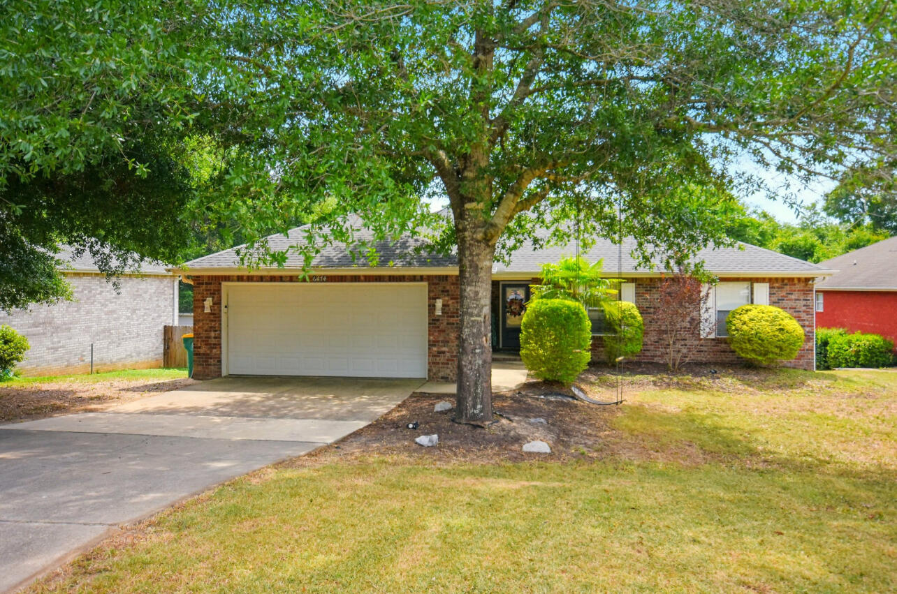 6474 Moonlight Lane Crestview, FL 32539 - Photo 2 of 39 a backyard of a house with yard and tree
