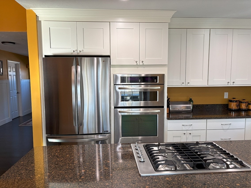 14 Cavite Street Devens, MA 01434 - Photo 10 of 40 a kitchen with granite countertop a refrigerator and a stove top oven