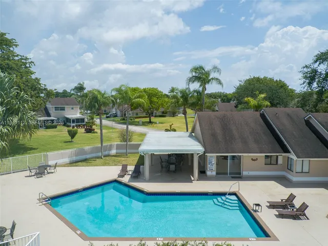 a view of a house with swimming pool and sitting area