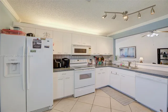 a kitchen with white cabinets and white appliances