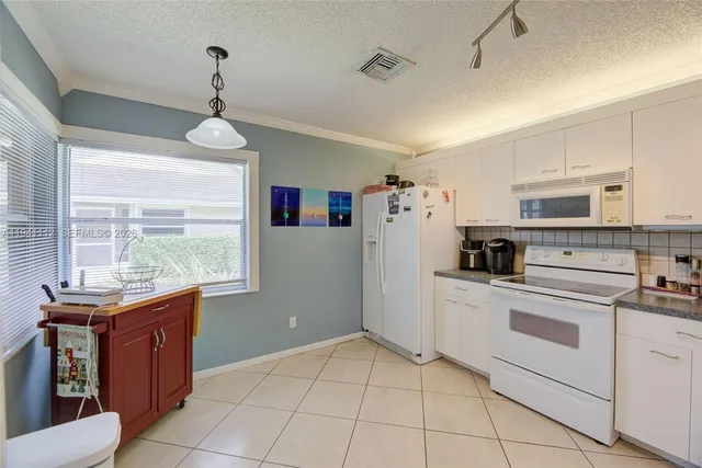 a kitchen with stainless steel appliances granite countertop a refrigerator sink and stove